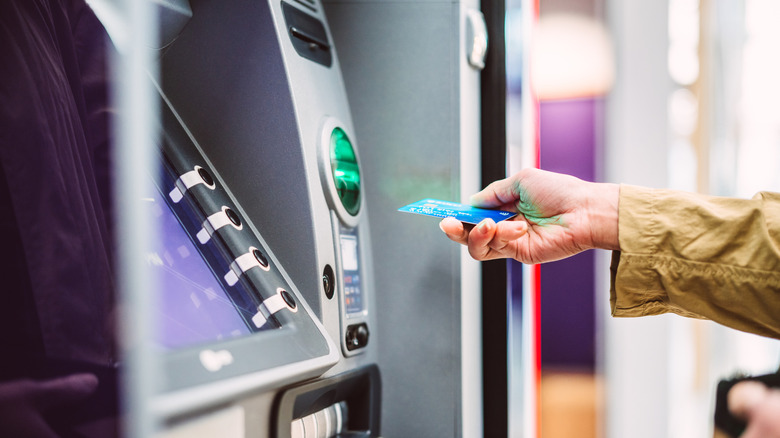 Person placing card into an ATM